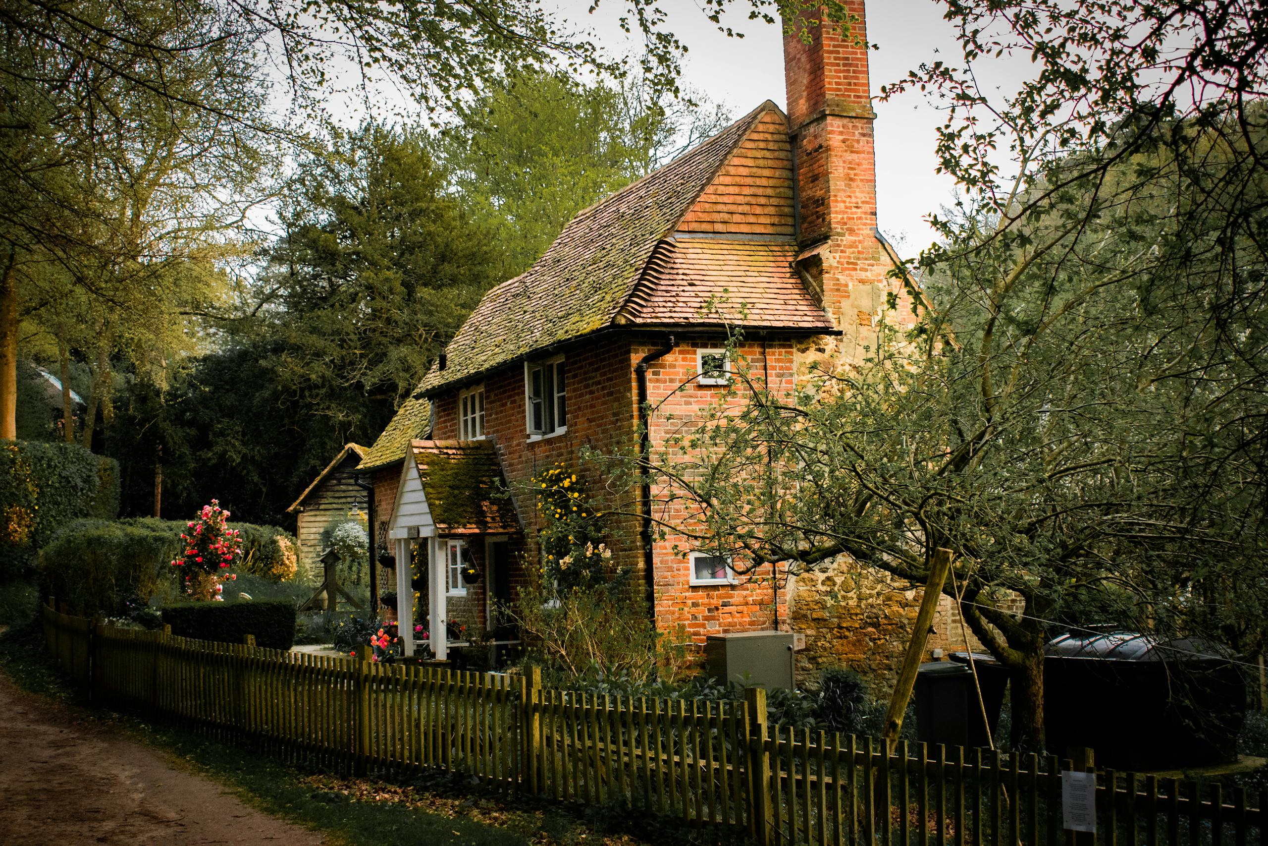 Picturesque brick cottage nestled in a lush garden setting, showcasing rustic charm and tranquility.